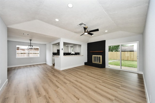 10415 Towne Oak Ln, Sugar Land, TX 77498 - unfurnished living room featuring a brick fireplace, lofted ceiling, light wood finished floors, a chandelier, and ceiling fan