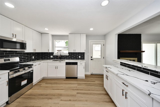 10415 Towne Oak Ln, Sugar Land, TX 77498 - kitchen with appliances with stainless steel finishes, backsplash, recessed lighting, white cabinetry, and light wood-style floors