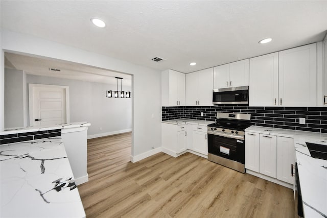 10415 Towne Oak Ln, Sugar Land, TX 77498 - kitchen featuring stainless steel appliances, light wood finished floors, white cabinetry, and recessed lighting