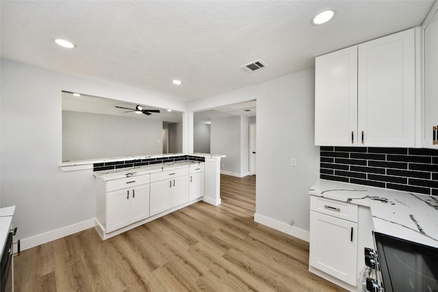 10415 Towne Oak Ln, Sugar Land, TX 77498 - kitchen featuring light wood-type flooring, white cabinetry, a peninsula, and recessed lighting