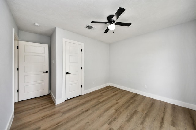10415 Towne Oak Ln, Sugar Land, TX 77498 - unfurnished bedroom featuring wood finished floors, ceiling fan, and a textured ceiling