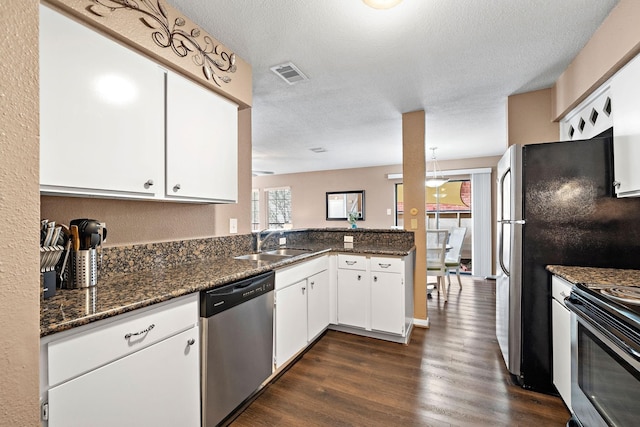 2211 S Kirkwood Rd Unit 23, Houston, TX 77077 - kitchen with appliances with stainless steel finishes, dark wood-style flooring, white cabinets, a textured ceiling, and dark stone countertops