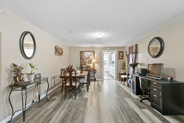 315 E Adoue St, Baytown, TX 77520 - dining space featuring light wood-style flooring, a textured ceiling, and an office area