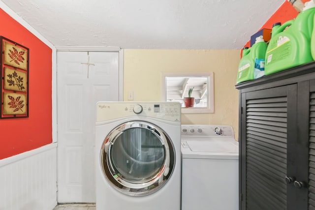 315 E Adoue St, Baytown, TX 77520 - laundry area with washer and clothes dryer, a textured ceiling, and a wainscoted wall