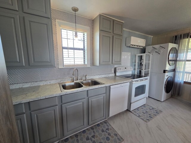 714 Caisson St, Surfside Beach, TX 77541 - kitchen featuring stacked washing machine and dryer, white appliances, gray cabinetry, and plenty of natural light