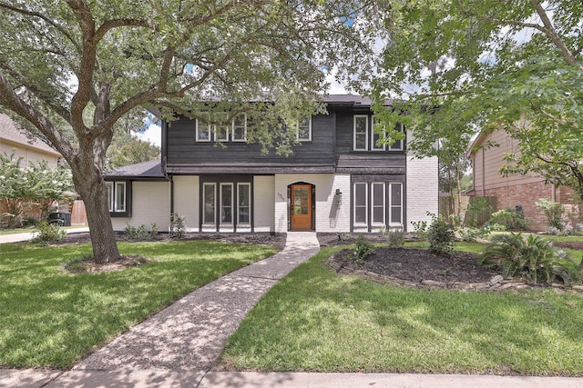 1711 Mossy Stone Dr, Houston, TX 77077 - traditional home featuring a front lawn, brick siding, and a porch