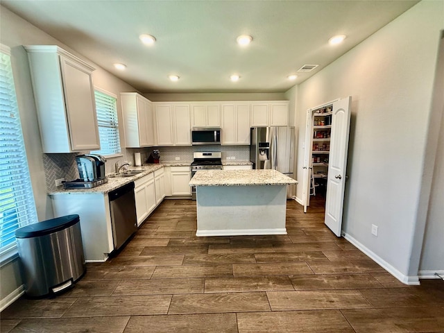 18534 Ariat Dr, Cypress, TX 77429 - kitchen featuring appliances with stainless steel finishes, wood tiled floors, white cabinetry, and recessed lighting
