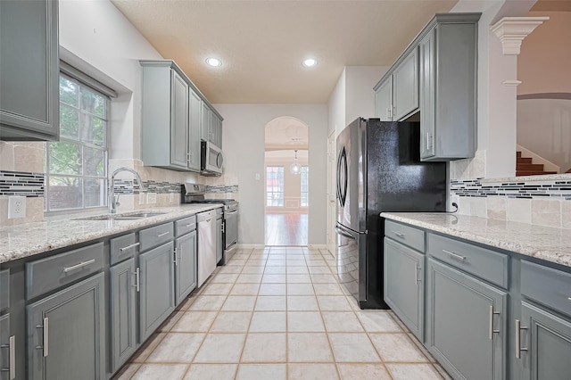 3402 Santa Catalina Ct, Katy, TX 77450 - kitchen with arched walkways, stainless steel appliances, gray cabinets, decorative backsplash, and recessed lighting