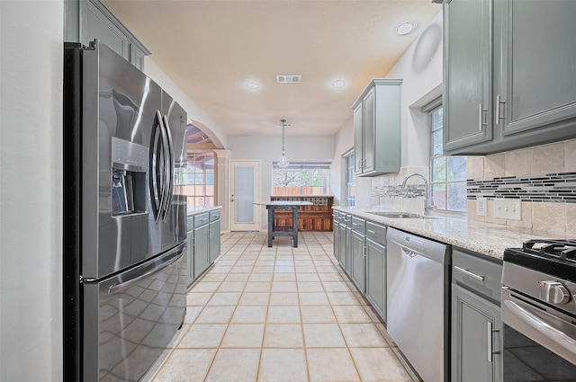 3402 Santa Catalina Ct, Katy, TX 77450 - kitchen with stainless steel appliances, gray cabinets, tasteful backsplash, light tile patterned floors, and recessed lighting