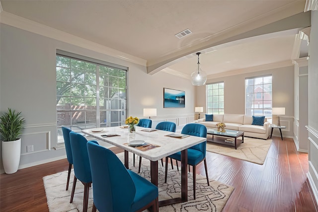 3402 Santa Catalina Ct, Katy, TX 77450 - dining space featuring a decorative wall, crown molding, wood finished floors, and wainscoting