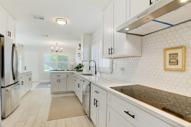 2510 Trailside Ct, Sugar Land, TX 77479 - kitchen with stainless steel appliances, under cabinet range hood, a chandelier, white cabinets, and tasteful backsplash