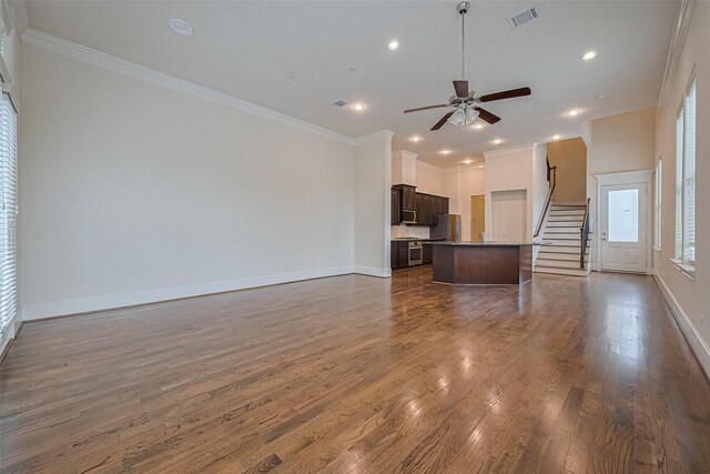 1035 E 28th St, Houston, TX 77009 - unfurnished living room with dark wood-style flooring, ceiling fan, recessed lighting, crown molding, and stairs