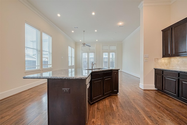 1035 E 28th St, Houston, TX 77009 - kitchen with crown molding, dark wood-style flooring, decorative backsplash, dark brown cabinets, and recessed lighting