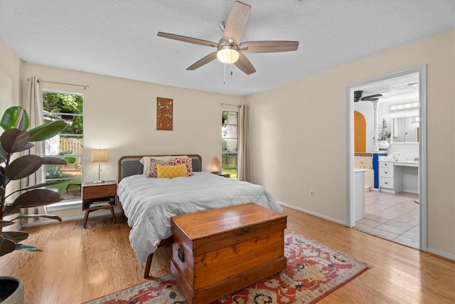 4638 Deer Point Dr, Spring, TX 77389 - bedroom featuring light wood-style floors, ensuite bath, and ceiling fan