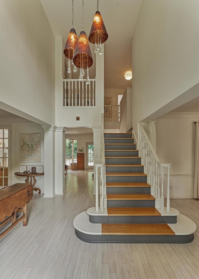 58 E Coldbrook Cir, The Woodlands, TX 77381 - stairway with wood finished floors and a towering ceiling