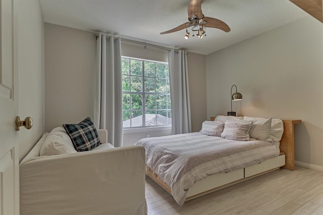 58 E Coldbrook Cir, The Woodlands, TX 77381 - bedroom with light wood-style flooring and a ceiling fan