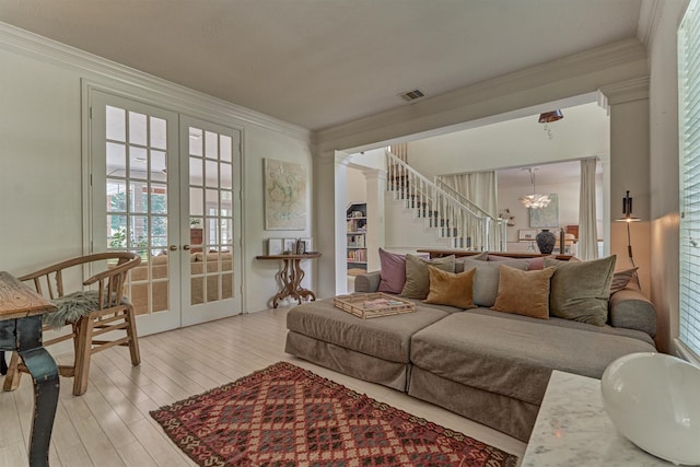 58 E Coldbrook Cir, The Woodlands, TX 77381 - living room featuring french doors, a chandelier, crown molding, stairs, and light wood finished floors