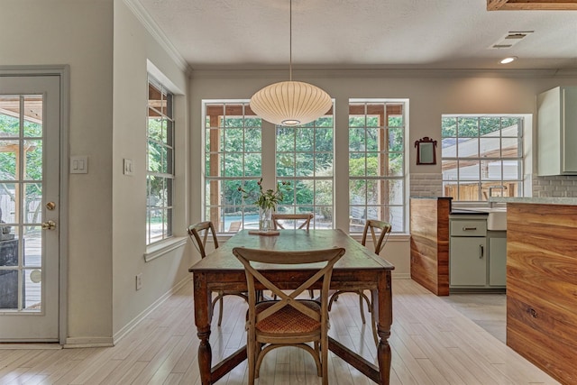 58 E Coldbrook Cir, The Woodlands, TX 77381 - dining room featuring light wood-style floors and ornamental molding