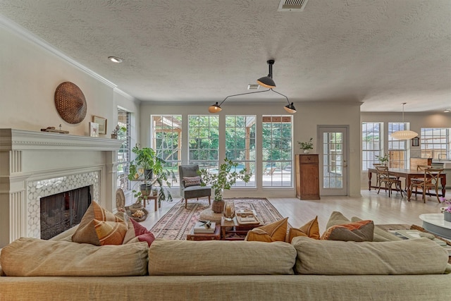 58 E Coldbrook Cir, The Woodlands, TX 77381 - living room with ornamental molding, light wood-style floors, a premium fireplace, and a textured ceiling
