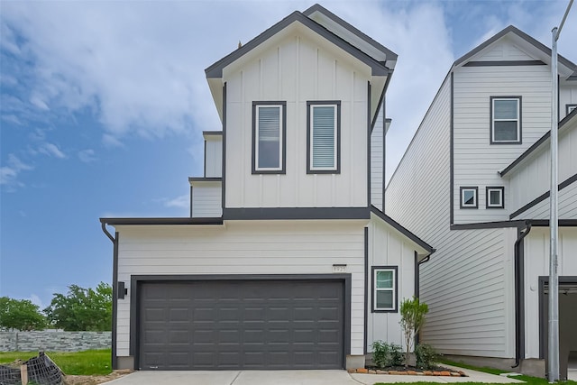 8915 Grovner Pl, Houston, TX 77055 - view of front of house featuring board and batten siding, driveway, and a garage
