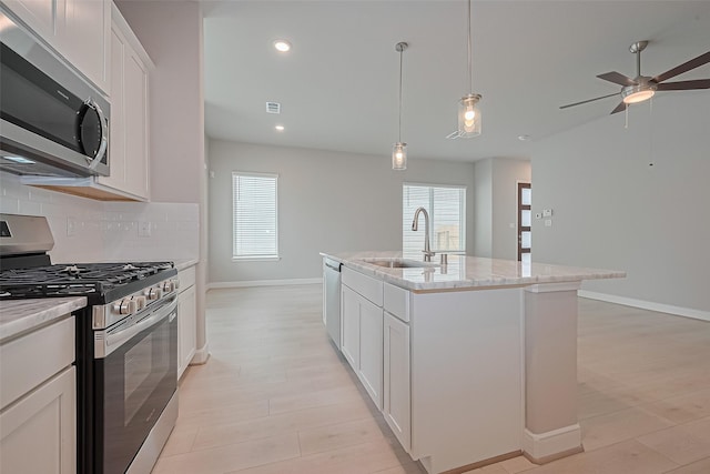 8915 Grovner Pl, Houston, TX 77055 - kitchen featuring stainless steel appliances, decorative backsplash, ceiling fan, decorative light fixtures, and light wood-style flooring