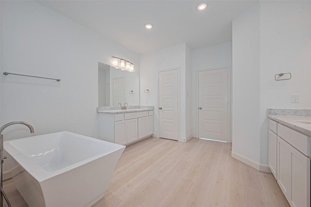 1609 Regents Gate, Houston, TX 77055 - full bath with two vanities, a freestanding bath, wood finished floors, and recessed lighting