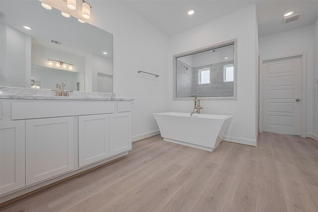 1611 Regents Gate Ct, Houston, TX 77055 - bathroom featuring a freestanding bath, wood finished floors, vanity, and recessed lighting