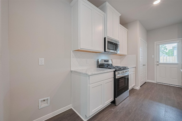 27076 Badger Way, Magnolia, TX 77354 - kitchen with appliances with stainless steel finishes, dark wood-style floors, tasteful backsplash, white cabinets, and light stone counters