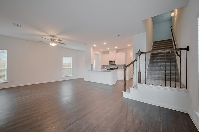 27097 Kestrel Trl, Magnolia, TX 77354 - unfurnished living room featuring dark wood-style floors, ceiling fan, stairway, and recessed lighting