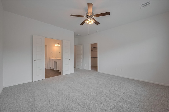 27097 Kestrel Trl, Magnolia, TX 77354 - unfurnished bedroom with carpet flooring, a spacious closet, connected bathroom, a ceiling fan, and a closet