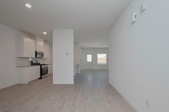 2204 Port Jackson, Texas City, TX 77568 - kitchen featuring stainless steel appliances, white cabinets, light wood-style floors, recessed lighting, and tasteful backsplash