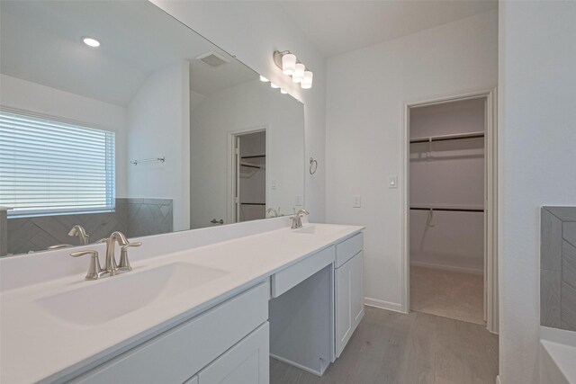 2204 Port Jackson, Texas City, TX 77568 - bathroom featuring wood finished floors, double vanity, and a walk in closet
