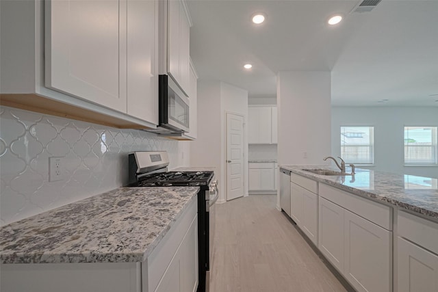 2204 Port Jackson, Texas City, TX 77568 - kitchen with stainless steel appliances, light stone countertops, white cabinetry, backsplash, and recessed lighting