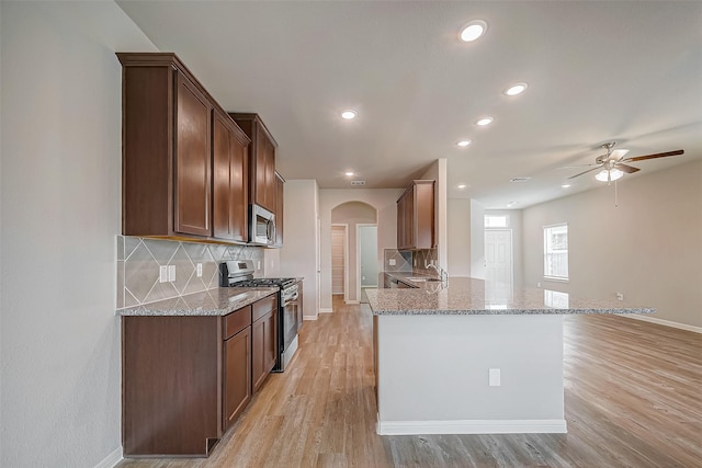 2127 Port Jackson, Texas City, TX 77568 - kitchen with stainless steel appliances, arched walkways, recessed lighting, light stone countertops, and decorative backsplash