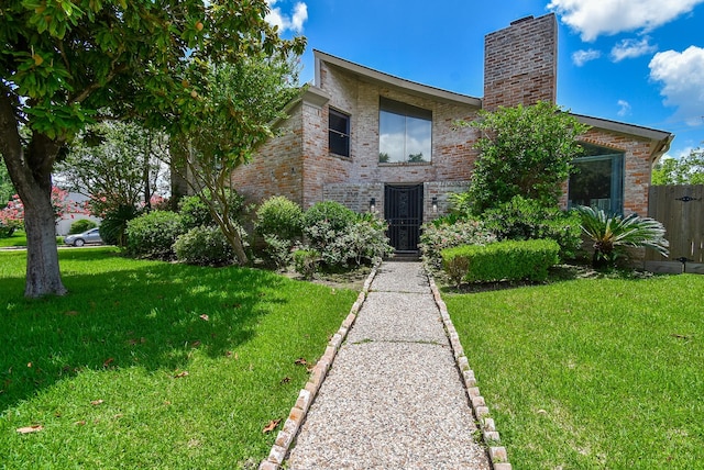 7719 Apache Plume Dr, Houston, TX 77071 - view of front of home with brick siding, a front yard, and a chimney