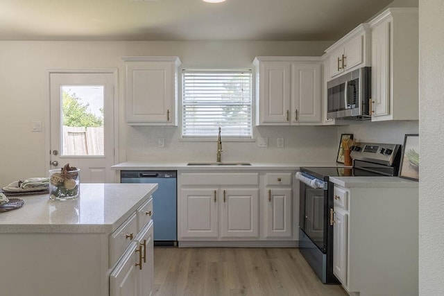 4310 Peppermint Hill Ln, Richmond, TX 77469 - kitchen with stainless steel appliances, white cabinetry, plenty of natural light, and light wood-type flooring