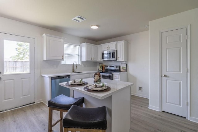 4310 Peppermint Hill Ln, Richmond, TX 77469 - kitchen featuring appliances with stainless steel finishes, white cabinetry, light countertops, and light wood-style flooring