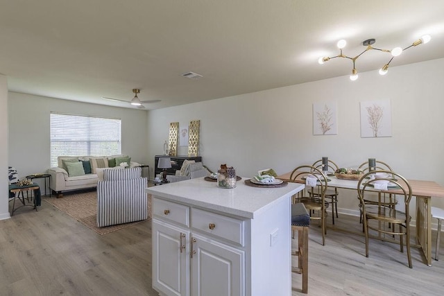 4310 Peppermint Hill Ln, Richmond, TX 77469 - kitchen with light wood-type flooring, a center island, white cabinets, and light countertops