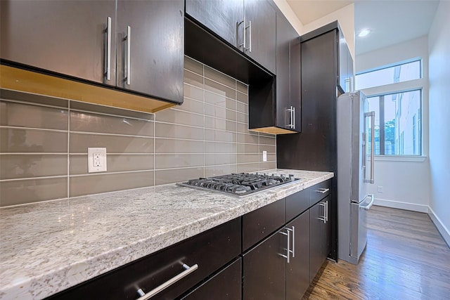 2205 Colorado St, Houston, TX 77007 - kitchen with stainless steel gas cooktop, wood finished floors, decorative backsplash, light countertops, and freestanding refrigerator