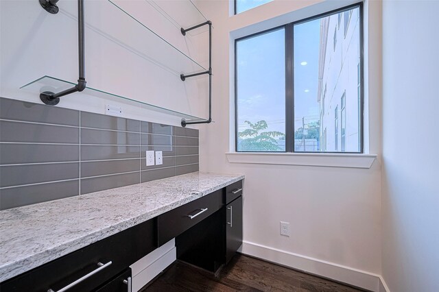 2205 Colorado St, Houston, TX 77007 - kitchen featuring dark cabinetry, dark wood-style floors, tasteful backsplash, and light stone counters