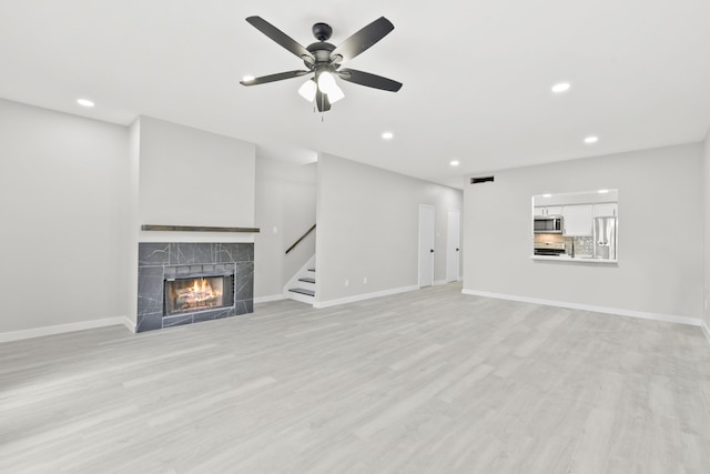 550 Wilcrest Dr Unit 550, Houston, TX 77042 - unfurnished living room with recessed lighting, a fireplace, a ceiling fan, light wood finished floors, and stairway