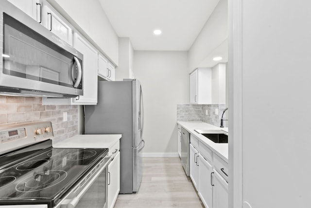 550 Wilcrest Dr Unit 550, Houston, TX 77042 - kitchen featuring appliances with stainless steel finishes, backsplash, white cabinetry, light countertops, and recessed lighting