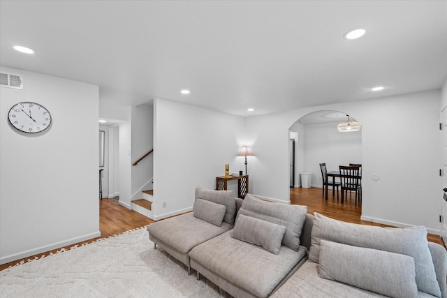 6697 De Moss Dr Unit 697, Houston, TX 77074 - living area with arched walkways, recessed lighting, stairway, and wood finished floors