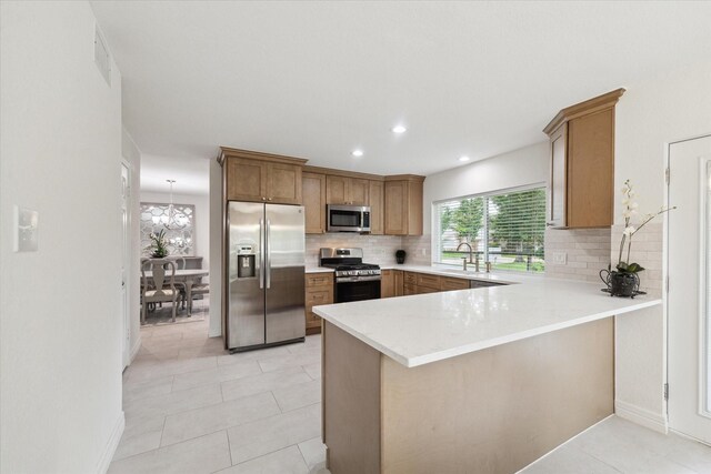 3403 Spring Arbor Ln, Sugar Land, TX 77479 - kitchen featuring stainless steel appliances, backsplash, light countertops, brown cabinetry, and a peninsula