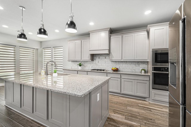 28702 Casen Ranch Ln, Fulshear, TX 77441 - kitchen featuring appliances with stainless steel finishes, recessed lighting, tasteful backsplash, wood finished floors, and an island with sink