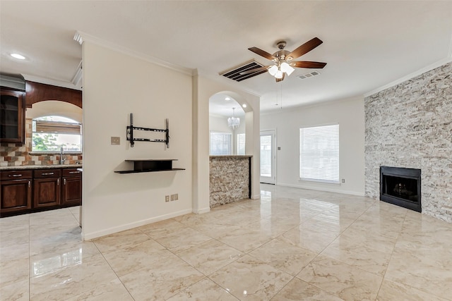 13351 Arlon Trl, Houston, TX 77082 - unfurnished living room featuring ornamental molding, a ceiling fan, a fireplace, arched walkways, and light marble finish flooring