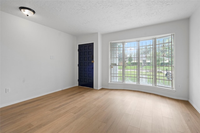 7019 Pyron Way, Houston, TX 77036 - unfurnished room with light wood finished floors, a textured ceiling, and plenty of natural light