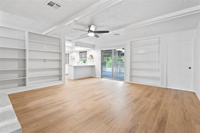 7019 Pyron Way, Houston, TX 77036 - unfurnished living room featuring built in shelves, a ceiling fan, light wood finished floors, and a textured ceiling
