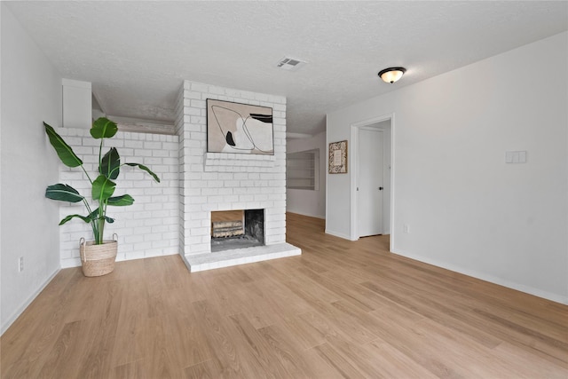 7019 Pyron Way, Houston, TX 77036 - unfurnished living room featuring a fireplace, wood finished floors, and a textured ceiling