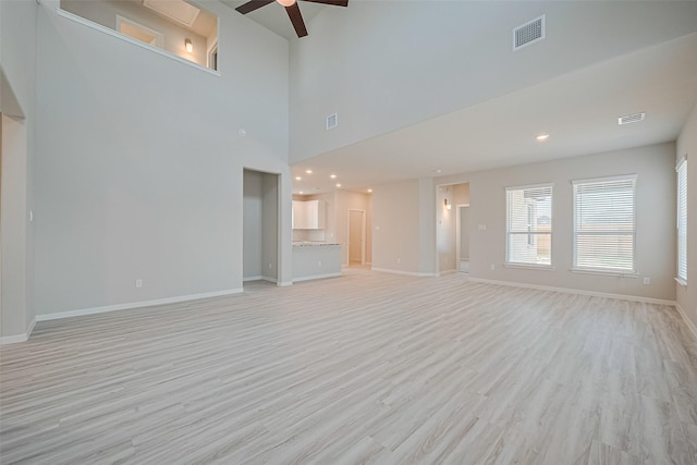 5819 Capri Forest Dr, Katy, TX 77493 - unfurnished living room with ceiling fan, light wood-type flooring, and a towering ceiling
